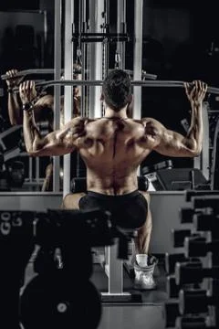 Guy bodybuilder with exercise machine Stock Photos