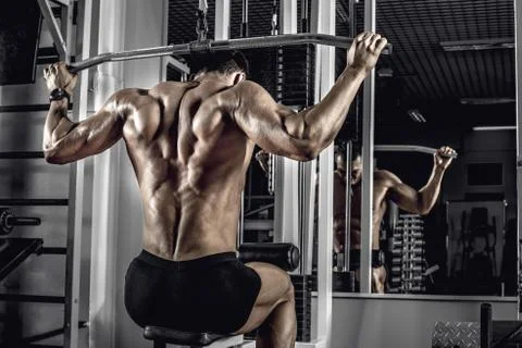 Guy bodybuilder with exercise machine Stock Photos