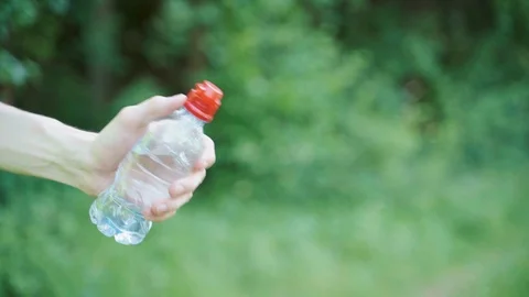 Guy with a bottle of drinking water on the background of nature Stock Footage 111909182