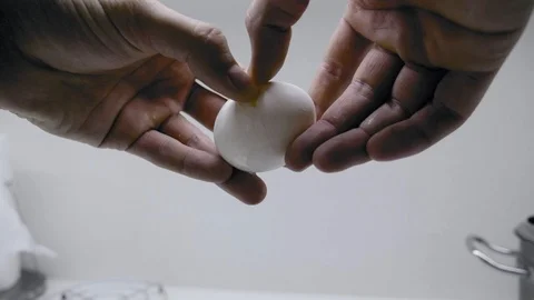 The guy breaks chicken eggs and fries them in a griddle, on an induction cooker. Stock Footage 107153751