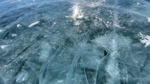 The guy breaks a piece of ice smooth transparent blue ice of frozen Lake Baikal Video stock 151065817