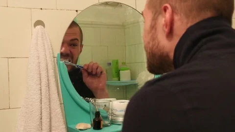 The guy is brushing his teeth with toothpaste. Stock Footage 75441549