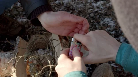 A guy building a campfire with logs during winter Stock Footage 233898426