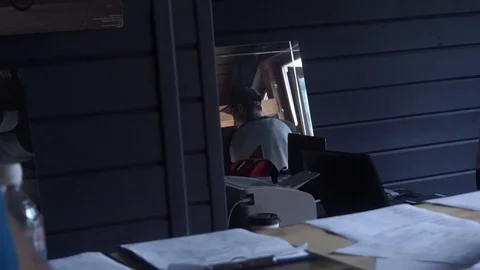 Guy in the building is talking to people and looking out the window Stock Footage 103221625