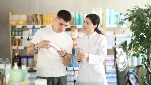 Guy buys gel for burns at pharmacy, pharmacist offer help Stock Footage 335616495