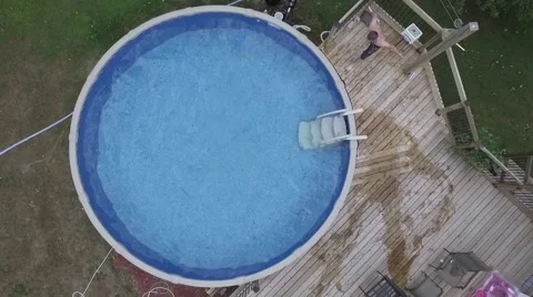 Guy cannonball into swimming pool slow mo Stock Footage