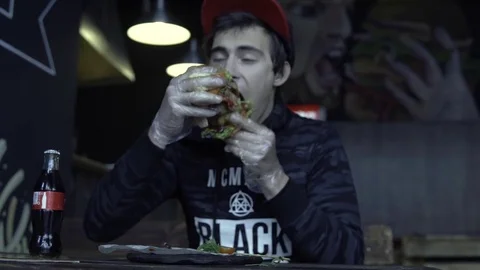 The guy with the cap is eating a hamburger 動画素材 85326238