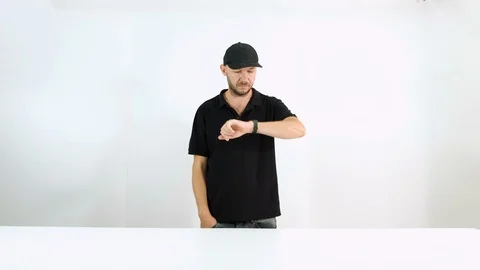 The guy in the cap is late and looks at his watch Stock Footage 102783305