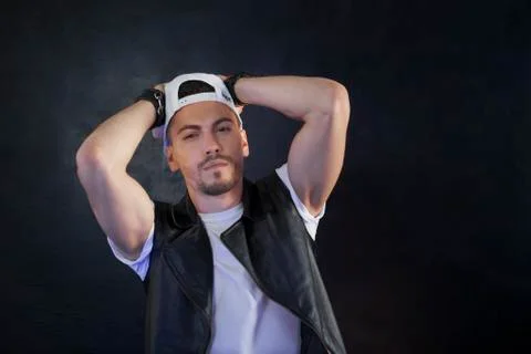 A guy in a cap posing against a black background Stock Photos