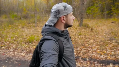The guy in the cap walks through the autumn forest. Slow motion. A nice place Stock Footage 101917649