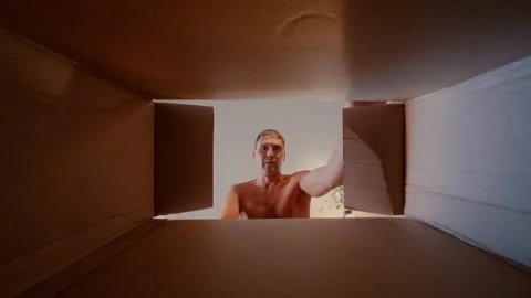 The guy carefully opens the box and examines the find lying at the bottom. Stock Footage 316911417