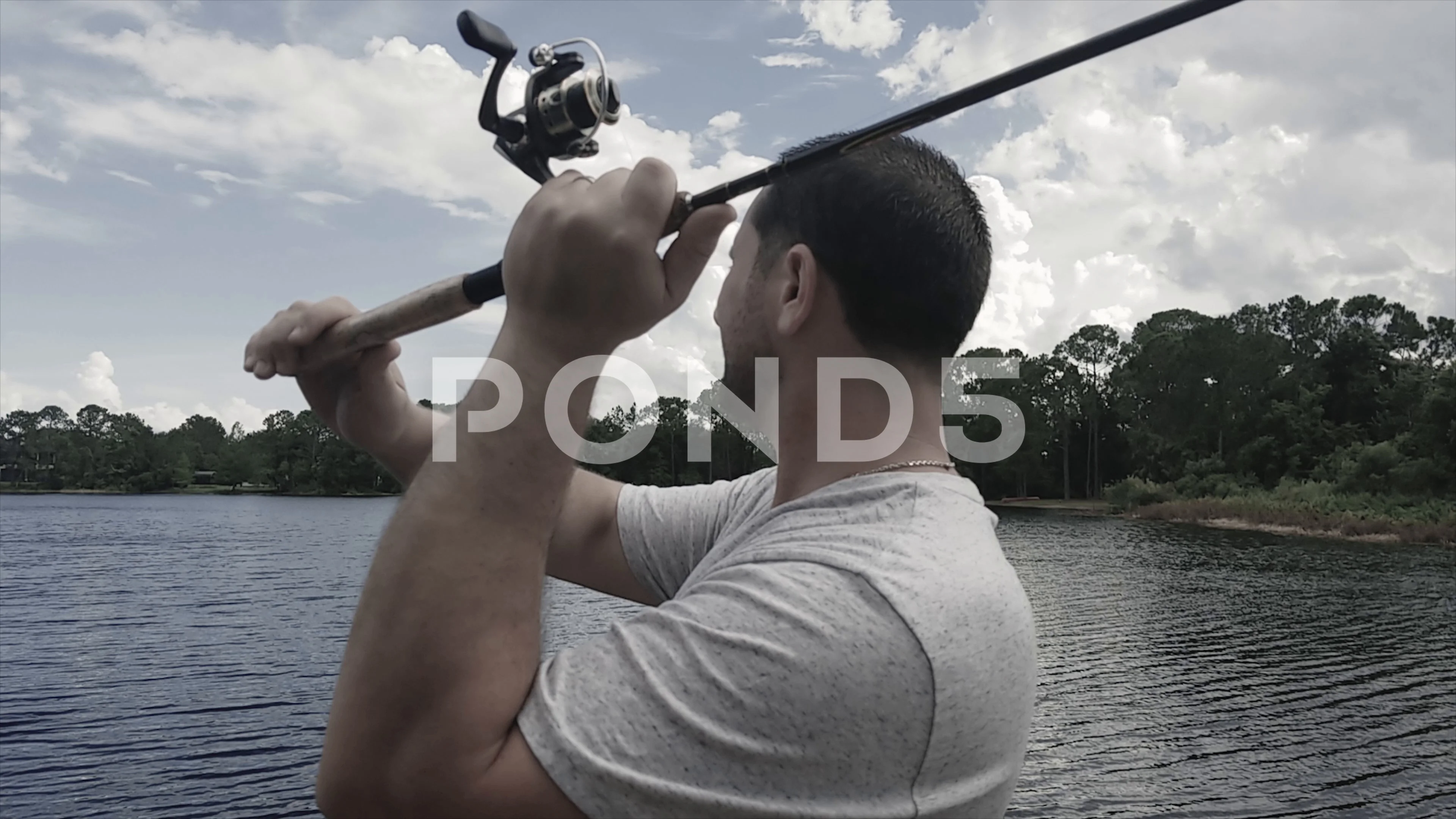 A guy casting a fishing pole into a lake, Stock Video