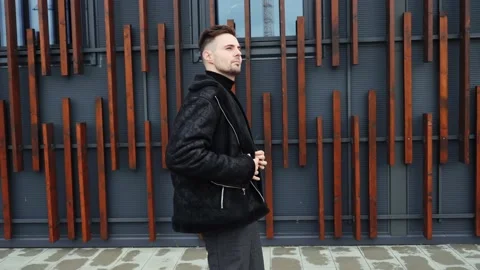 Guy in casual clothes adjusts his jacket and looks around, man goes to work. Video stock 221319608