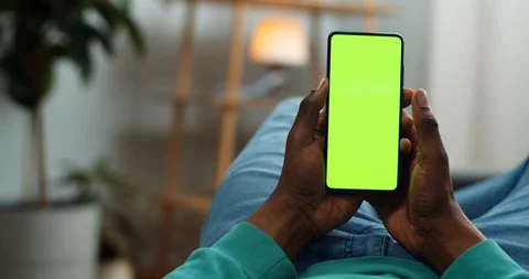 Guy in casual clothes lying on couch and touching smatphone mock up display Video stock 129536805