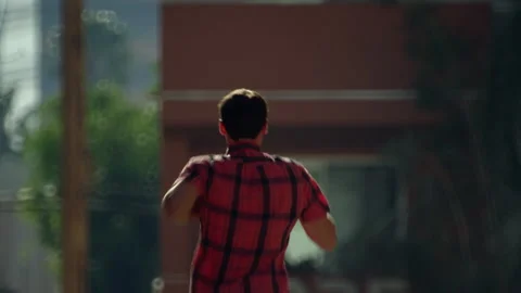 A guy in casual clothes quickly runs down the street in Los Angeles. Stock Footage 194011478