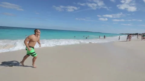 Guy Catches Ball On Beach of the Bahamas Stock Footage