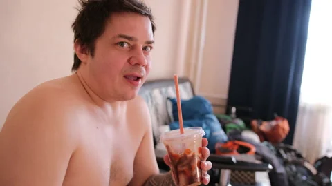 The guy is caught eating pizza and drinking a milkshake Video stock 151499076