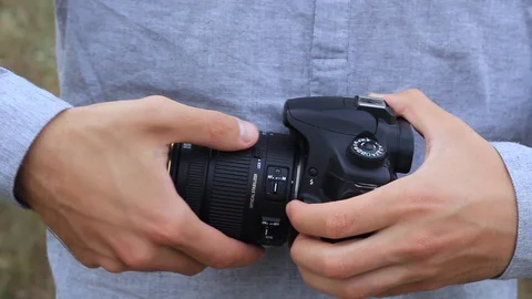 The guy changes the lens on the camera Stock Footage 94742781