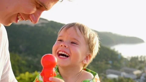 The guy with the child is playing fun, laughing. Close-up Vidéo 74763898