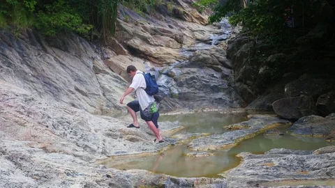 The guy with the child standing on the shore of a mountain river. Sports Vidéo 75682367