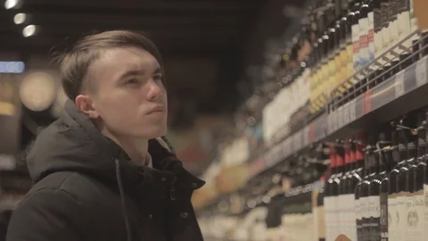 The guy chooses alcohol in the store Stock Footage 89875434