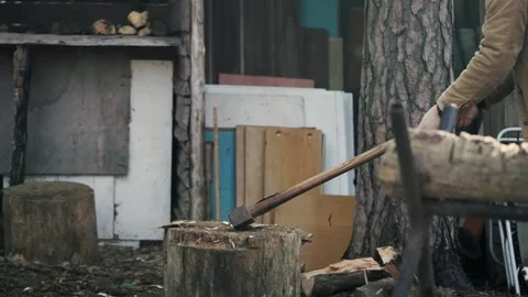 The guy chopping the log into pieces with a cleaver Stock Footage 234537542