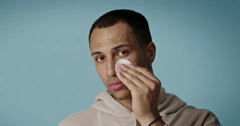Guy cleaning face with white pad. Handsome man applying lotion with cotton pad Stock Footage 225057982