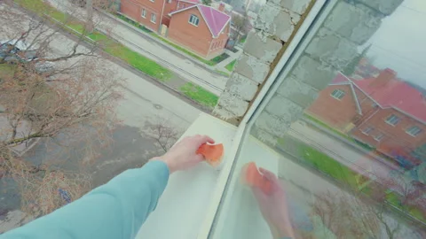 A guy cleans a window outside at the height of the fourth floor. Видео 334129647