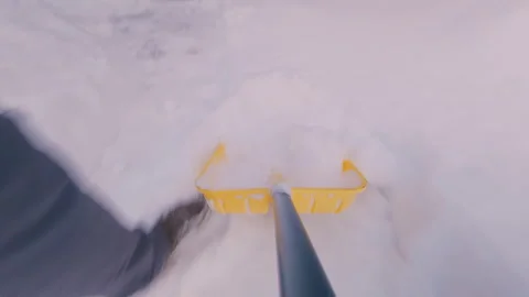 A guy clears snow with a shovel to get to the building. From the first person. Stock Footage 325717276
