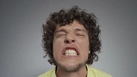 Guy clicks his teeth, makes faces with his jaws in studio, makes faces, bulging Stock Footage 140785757