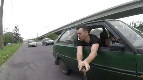 The guy climbed out of the car window and filmed himself on a gopro camera Stock Footage 169513389