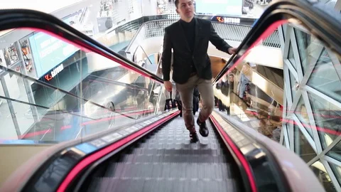 Guy climbs the escalator in the mall Stock Footage 128674371