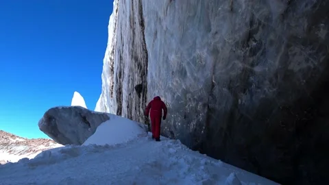 The guy climbs up a large glacier in the mountains Video stock 234448070