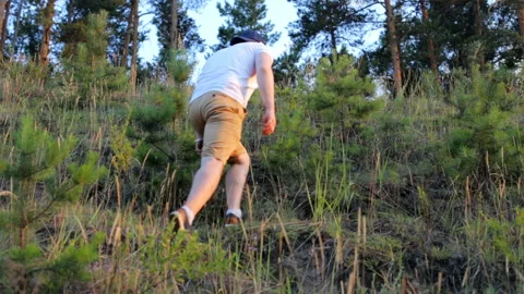 A guy climbs a mountain in the forest Video stock 92662154