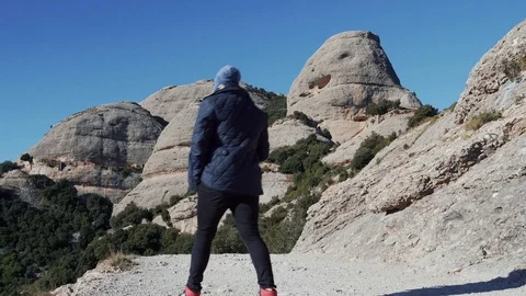 The guy climbs the mountain on a sandy road near the monastery montserat, Spain Stock Footage 101270312