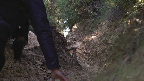 The guy climbs up the steep narrow rocky road in forest Stock Footage 101269859