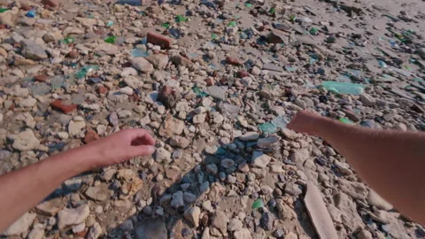 A guy collects glasses from broken bottles on the beach. Stock Footage 339311288