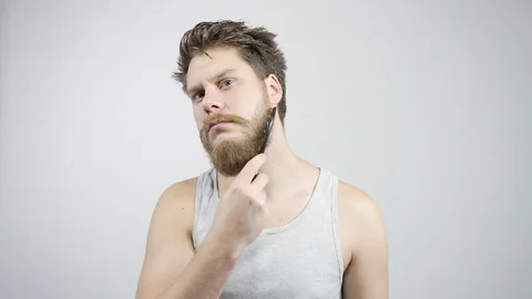 The guy combing his thick beard looking in the mirror Stock Footage
