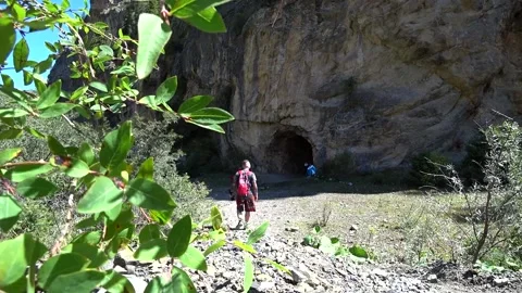 The guy comes to a large cave in the rock. 動画素材 161808798