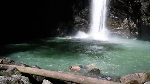 Guy comes up from a large waterfall. Video stock 122966094