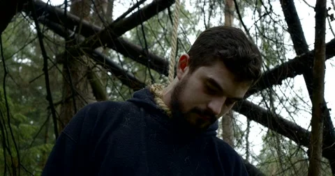 A guy commits suicide with a rope loop in the woods. A suicidal man, a noose Stock Footage 172338841