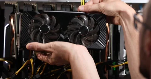 The guy connects the 8 pin power connector to the vga card near the mining farm Stock Footage 156040448
