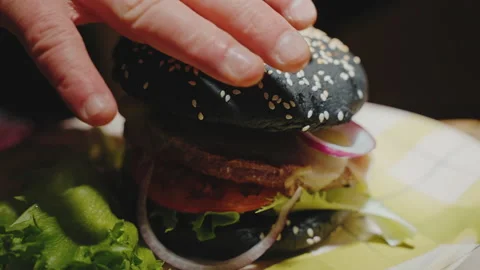 The guy cooks a hamburger and puts a bun Stock Footage 171488025