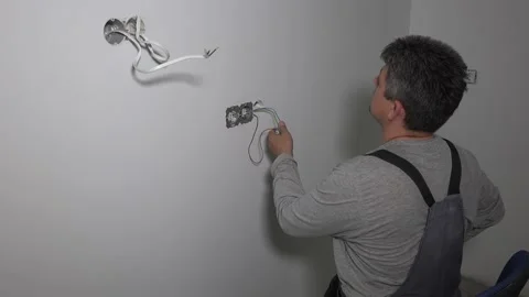 Guy with cordless drill screw electrical outlet. Do it yourself 스톡 동영상 148607230