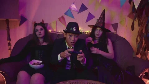 The guy in the creepy suit is actively playing a game console Stock Footage 211465592