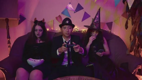 The guy in the creepy suit is actively playing the console Stock Footage 211466450