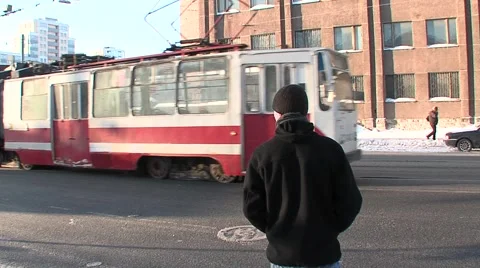 The guy crossing the road, sits in the Russian tram leaves, winter, cold Stock Footage 5186436