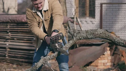 The guy cuts the branches with a chain-driven electric saw Stock Footage 234536772