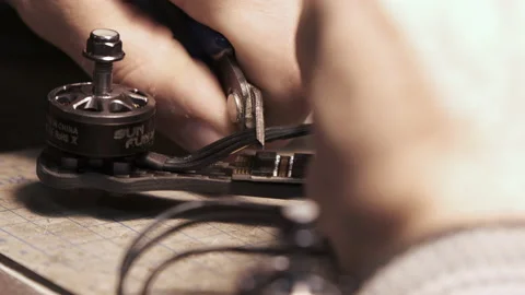 The guy cuts off the extra cable for the FPV drone. Drone assembly Stock Footage 139541307