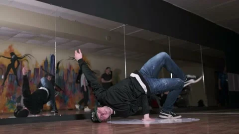 Guy dancing break dance in the hall with mirrors. Youth subculture. Slow motion Stock Footage 131879201